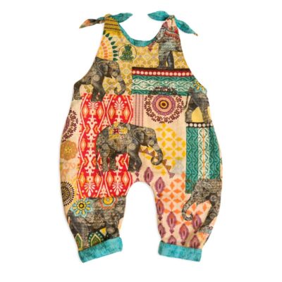 The front side view of Baby Blue by Cool Blue Maui’s Elephant Walk Romper which has large gray elephants walking among multi color batik motifs and a jade green scratch fabric cuff.